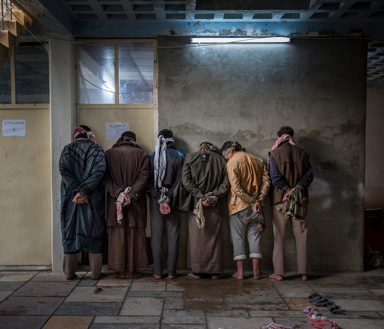 A group of bound, blindfolded Iraqi men wait to be interviewed by Kurdish security near Kirkuk, Iraq.   Professional Current Affairs & News category.