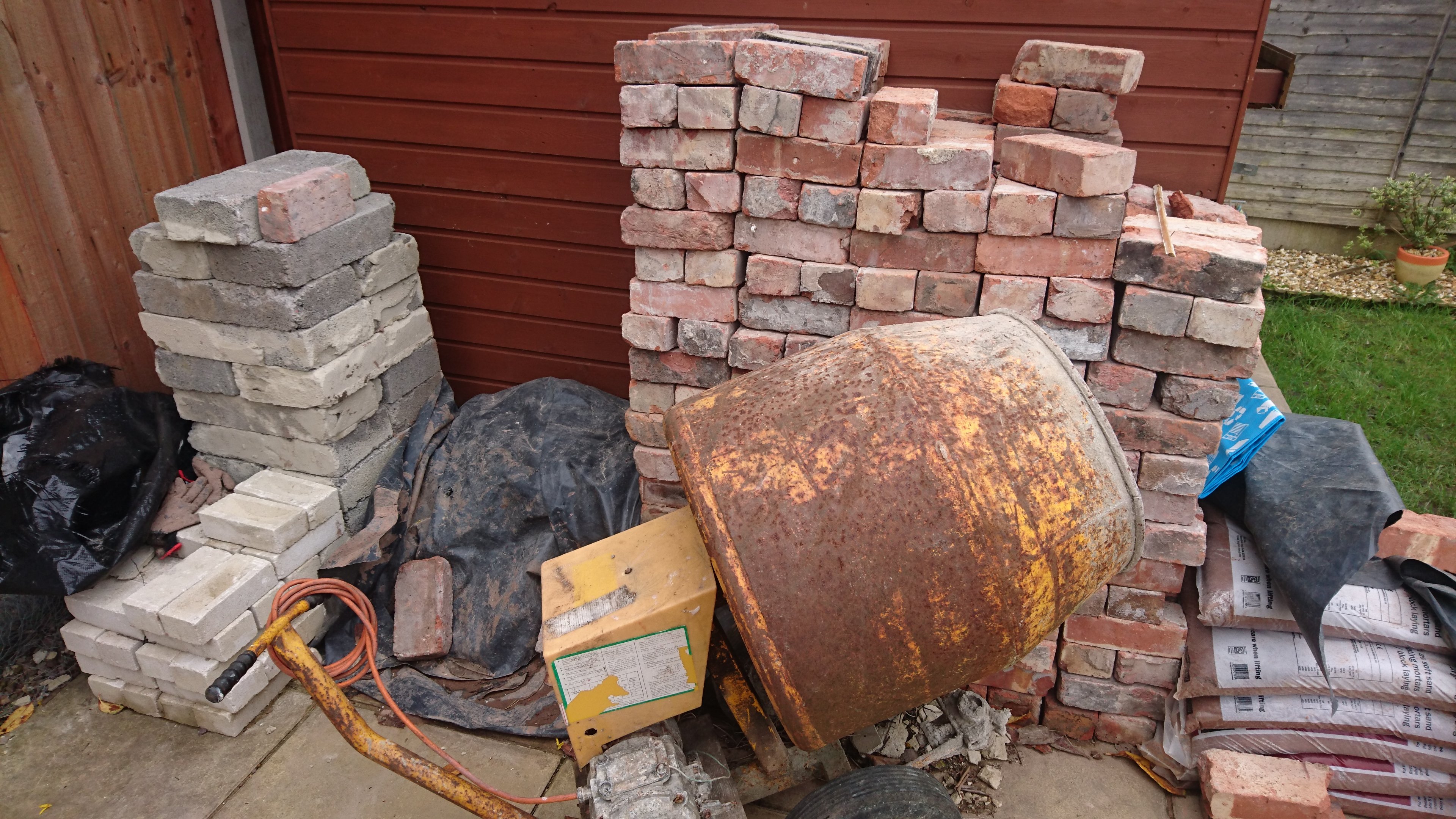 "First, gather all the materials, tools and a cement mixer. You need a large and small trowel, a large and small spirit level and a brick jointer. A cement mixer is essential to give you consistent mixes of mortar. Ignore all the bricks to the left; they were foraged and never ended up being used. I bought 350 reclaimed bricks from a popular auction site, 16 bags of sand and 4 bags of cement."