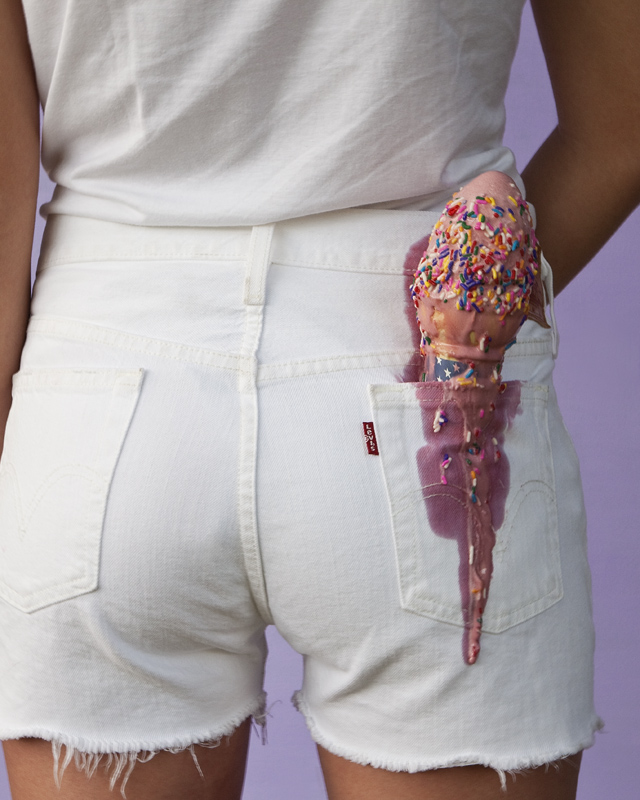 Woman wearing white shorts with an ice cream cone in her back pockets.