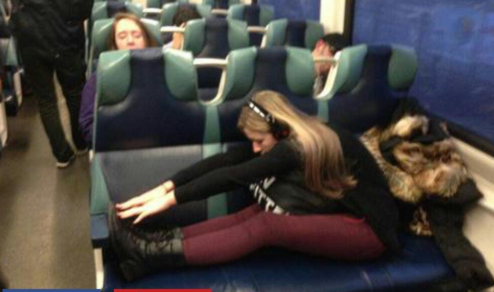 Inconsiderate woman taking up 3 seats on the train to do her stretching exercises.