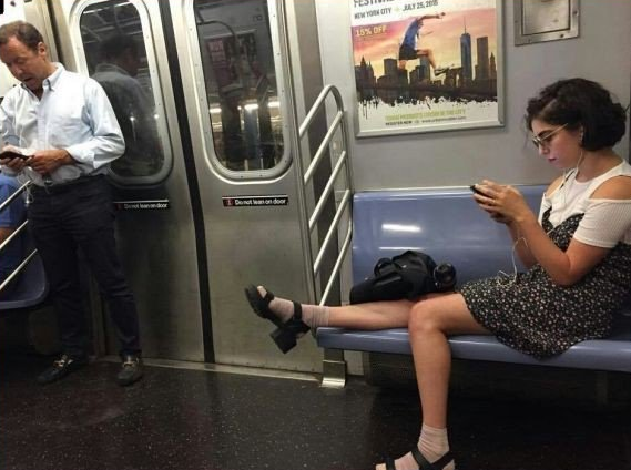 Lady lounging woman on the subway taking up way more than 2 seats.