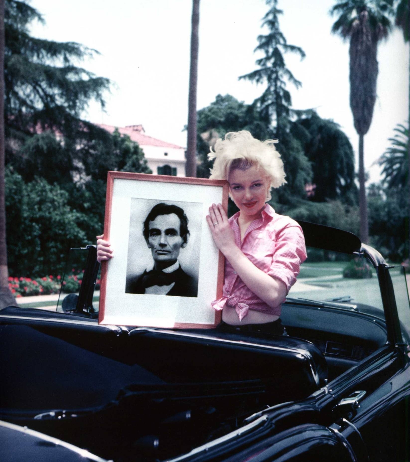 Marilyn Monroe holding a portrait of her hero, Abraham Lincoln, in 1955. She bought numerous pictures of him, went to his museums, and read up on all she could about his life.