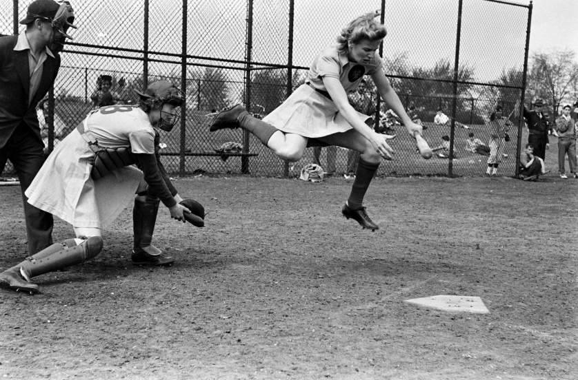 Mary "Bonnie" Baker goes to catch a ball that was just a bit inside during an All-American Girls Baseball League game in 1943. The batter is unnamed, but clearly has some impressive dodging skills.