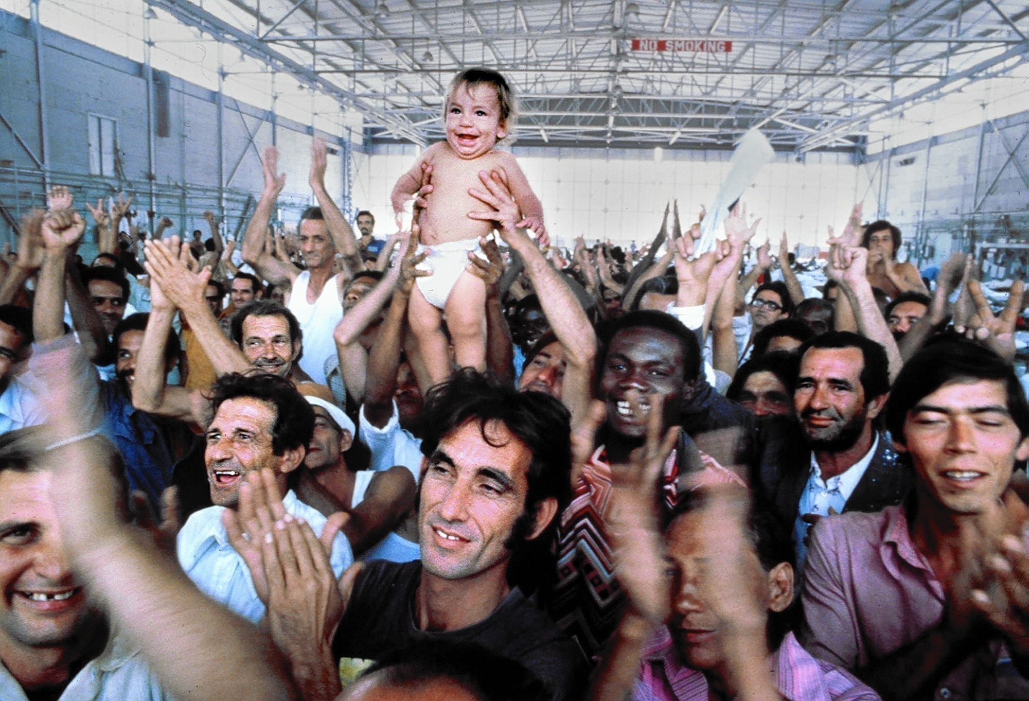 Happy Cuban refugees applaud after receiving an announcement saying they are staying in the US while in a camp in Miami in 1980.