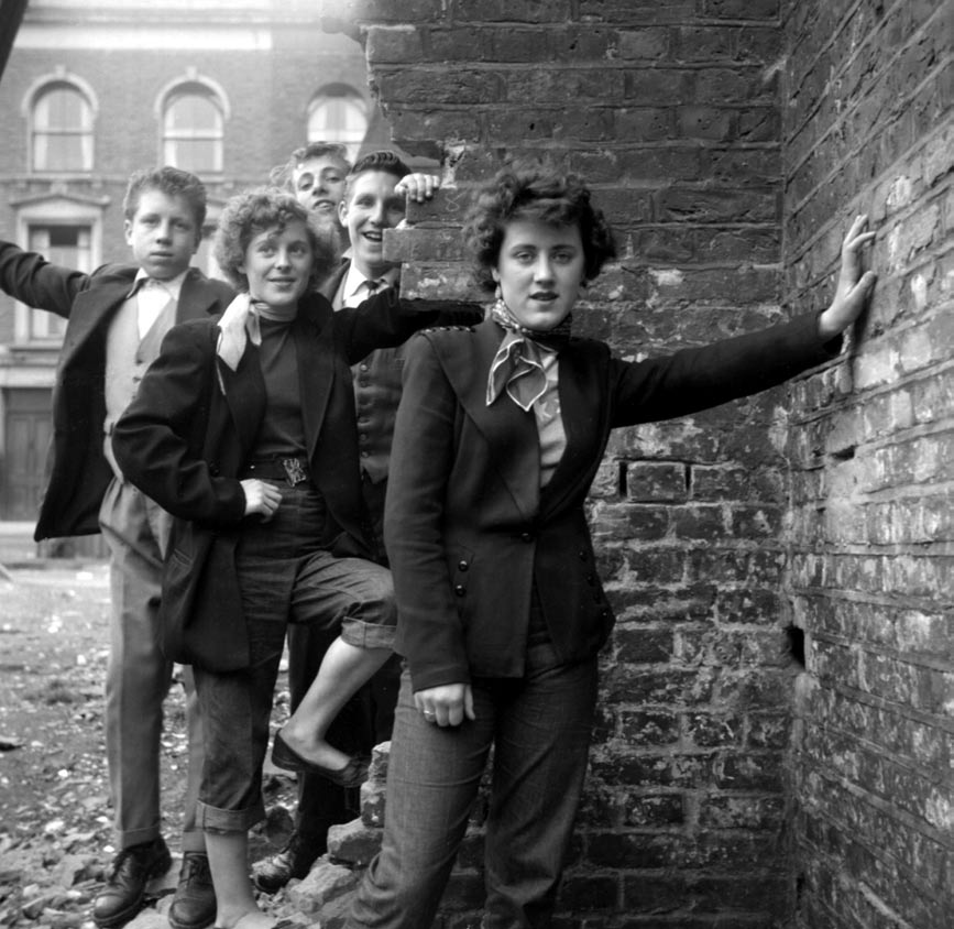 Teddy Boys and Girls in London, England in 1952. The name derived from wearing clothes that were partly inspired by the styles worn by dandies in the Edwardian period (early 1900s). Colors and patterns could also signify a gang or group the youths would be affiliated with.