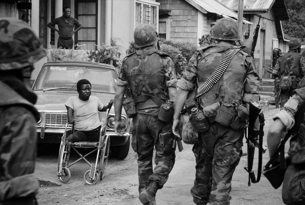 US soldiers walk past a disabled man during the Invasion of Grenada in 1983. In 3 weeks, the US took complete control of the tiny island. The invasion was a result of the execution of the pro west leader Maurice Bishop and the support from the Soviet Union and Cuba to turn Grenada communist, as well as to protect numerous American citizens there.