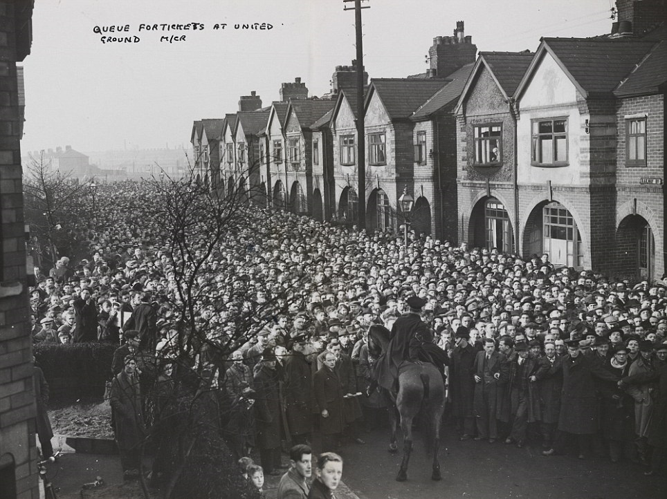 Police hold back a massive crowd trying to get tickets to a Manchester United game in Manchester, England in 1950. Limited tickets for a big game were available, so a "stampede" of fans came out to try and get some. A few injuries occurred before the police got things in order.