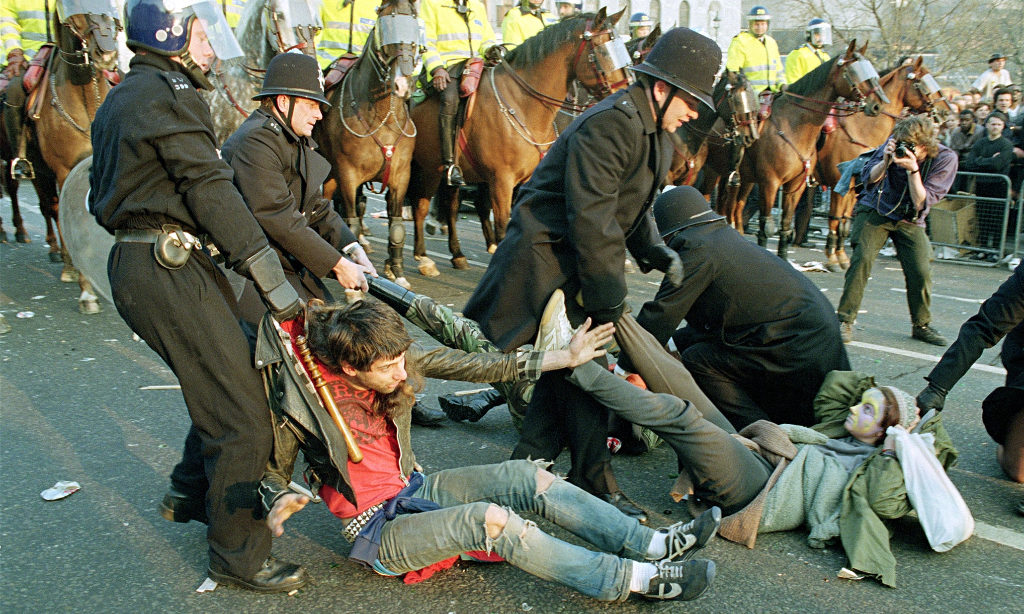 3 People are knocked to the ground and dragged away to be arrested during the Poll Tax Riot in London, England in 1990. The super unpopular new tax was the main driving force in Margaret Thatcher's resignation that very same year.