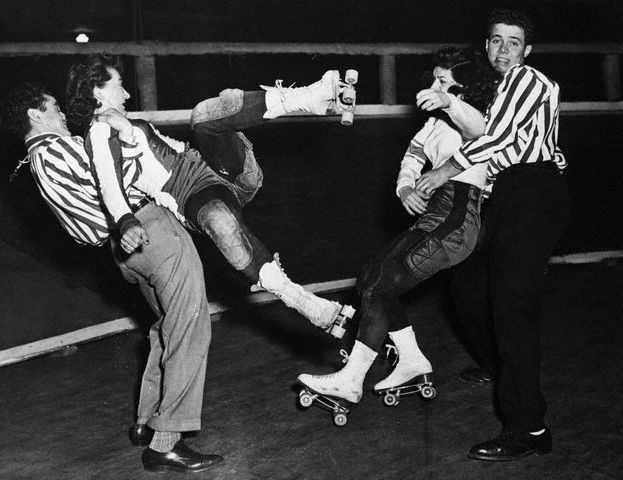 2 Roller Derby Girls are pulled off each other after fighting during a race in NYC, USA in 1948. After WWII, the sport took off for a time as the fierceness and violent nature of the races was a widely popular spectacle to watch.