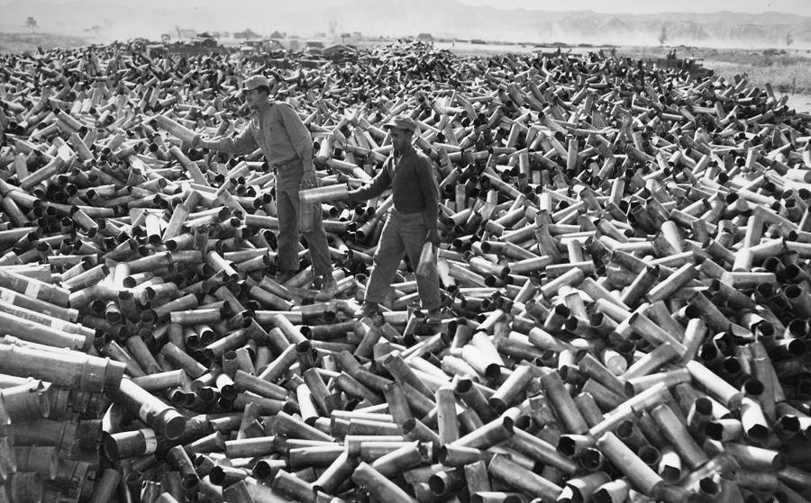 Soldiers pose on top of the discarded shells from fired rounds after a bombardment of an enemy position in the Korean War in 1952.