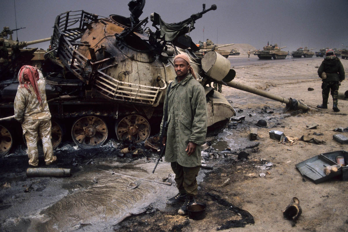 Soldiers who are part of the international coalition to free Kuwait after Iraq had invaded it stand next to a knocked out tank after the Battle of 73 Easting in the Gulf War in 1991. The Iraqi armor was so outdated the coalition absolutely obliterated any who did not run. Some 160 Iraqi tanks, 180 Iraqi personnel carriers, and 80 other Iraqi wheeled vehicles were destroyed, along with around 1,000 Iraqi soldiers killed. The coalition lost 2 vehicles, 1 to friendly fire, and had officially 1 killed. Some tank crews compared it to shooting fish in a barrel.