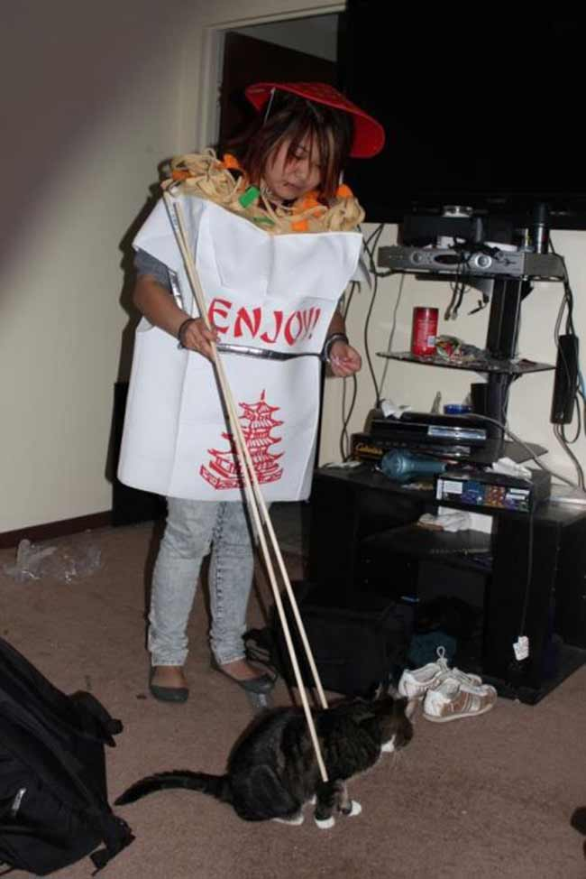 Woman cosplay dressed as chinese food picking up a cat with chopsticks