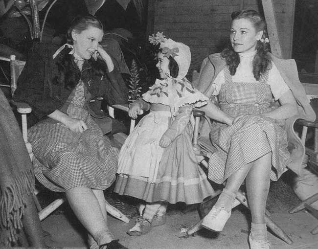 Judy Garland (left) sits with her body double Bobbie Koshay (right) and actress Olga Nardone on the set of The Wizard of Oz in 1939.