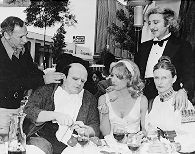 Mel Brooks goofs off with Peter Boyle's hair while Gene Wilder, Teri Garr and Cloris Leachman watch during a lunch break while making the film Young Frankenstein in 1974. Brooks always enjoyed interacting and keeping everyone relaxed during shoots. However, Leachman does not look amused.