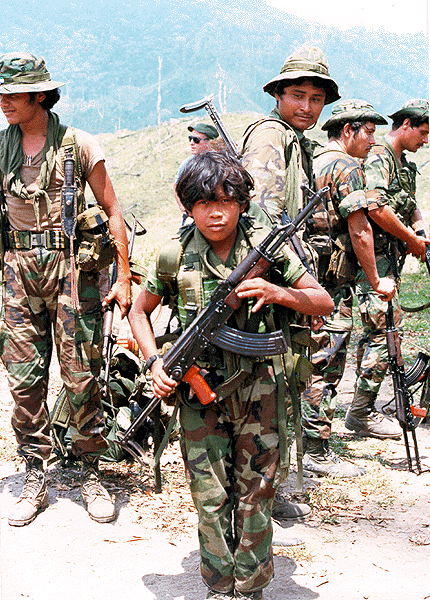 A child soldier poses with his unit for American journalists somewhere in the mountains of Nicaragua in 1984. This group was part of the Contras, which established themselves in 1981, which helped bring an end to the 28 year Nicaraguan Revolution in 1990. The US backed them, while the USSR backed the controlling FSLN. They fought to a stalemate, in which new elections were held that removed the FSLN from power in 1990. The USSR was struggling in the midst of its collapse which made supporting the FSLN risky during the elections, causing their downfall. From 1978 until the fighting stopped in 1989, up to 50,000 people died in this conflict.