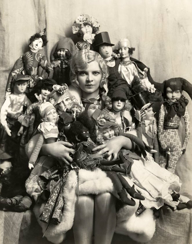 A woman poses with her boudoir doll collection in Paris, France in 1922. The dolls were all over France, England, Italy, Germany and the US. Notice how some of her dolls are of different ethnic complexions, those were extremely rare even back then, and only really came from France and parts of the US.