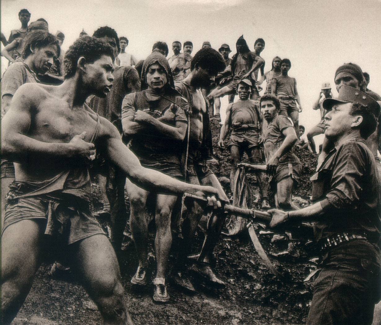 A fearless worker grabs the gun of a soldier during clashes between the Serra Pelada gold mine workers and military police in Brazil in 1986. The military seized the mine, and had all the workers removed. This was actually done because the workers were being exploited by the owners, as basic necessities were being sold to the workers at 5 times normal prices. However the government wouldn't keep the mine running after it took it over, but instead shut it down, causing all the thousands of workers to be unemployed.