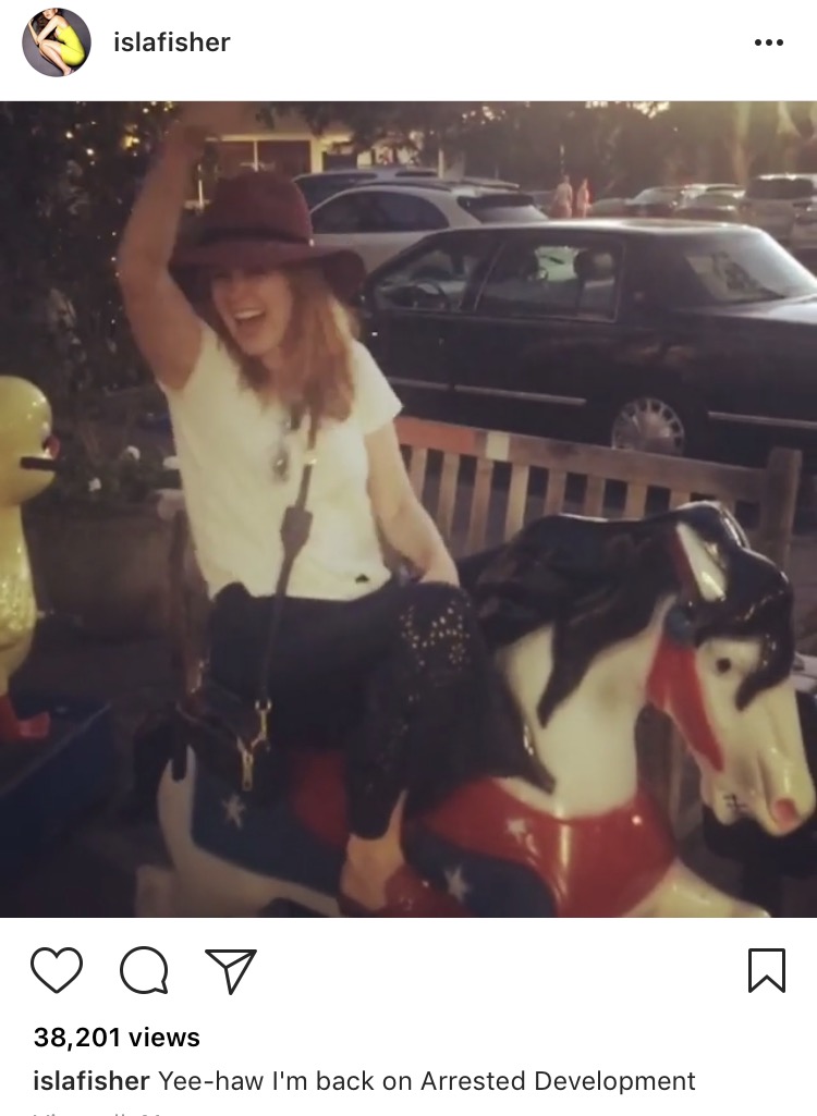 Isla Fisher riding a little kids ride