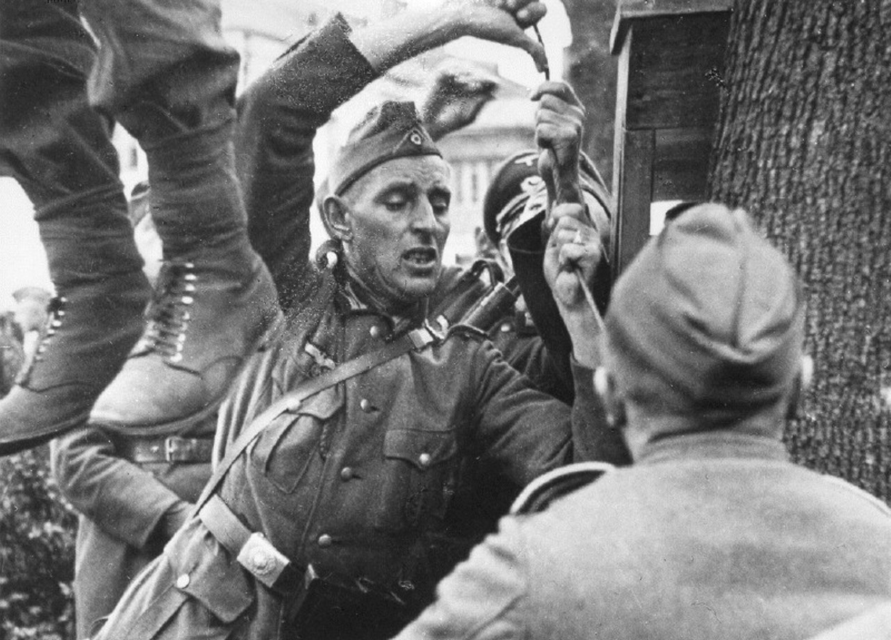 German soldiers hang a Russian partisan near Minsk, Belarus in 1941. The Germans would quickly execute partisans when caught on the Eastern front. They execute men and women alike.