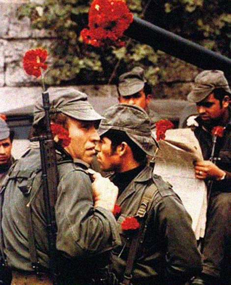 Portuguese soldiers read updates in the paper during the Carnation Revolution of 1974. This was a military coup that went over pretty peacefully, and soldiers would decorate themselves and their weapons with carnations to show solidarity with the people. However the people did not want a military Junta in control, and confrontations with militia occurred. The entire country was conflicted for a few years, causing the foreign conflicts in Angola and Mozambique in Africa to break down, despite Portugal firmly winning them at the time. Eventually this also caused almost all Portuguese colonies to be lost.