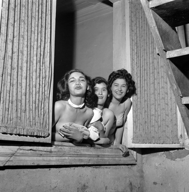 3 Prostitutes hang out their window trying to entice customers in Santiago, Chile in 1950. Chile had already an entire district set up for the growing profession by 1950.