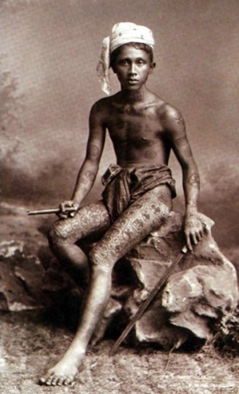 A young man shows off his tribal tattoos known as Lanna tattoos somewhere in northern Thailand in 1895. These tattoos still exist in some small villages in the area today, but are getting more and more uncommon and may eventually disappear.
