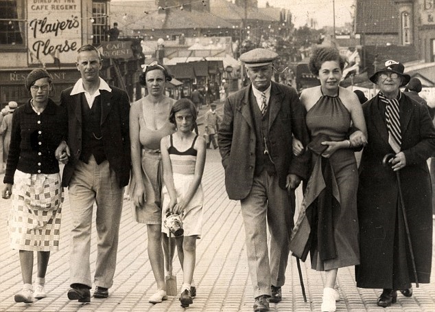 Two families walk the promenade in Mablethorpe, Lincolnshire, England in 1935. This picture is in some British fashion libraries to show the drastic change of fashion from generation to generation of that time period.