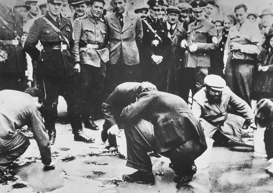 A crowd gathers to laugh at Jews who are forced to clean the pavement in Vienna, Austria in 1938. This would be the beginning of forceful manual labor, constant abuse, deportation and death for the Jews. Despite was was later said you can clearly see that civilians participated in the process.