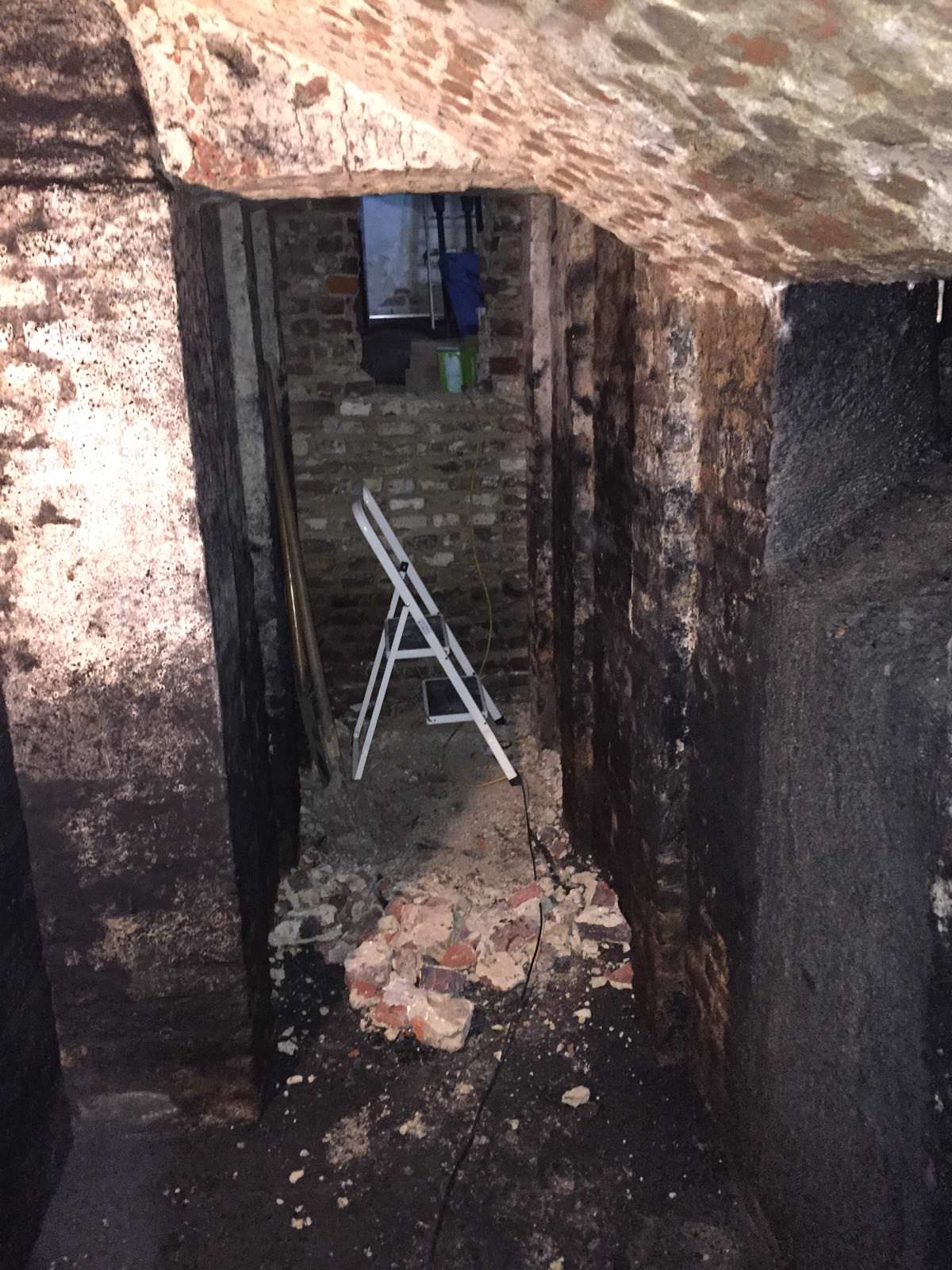 "Other side at the back of the wall inside the corridor. At the right hand side you can see what is now determined as a coal chute. edit : the blackness on the walls is leftover residue from the coals. You can also see the wall is totally covered where they poured the coals in (on the right side)."