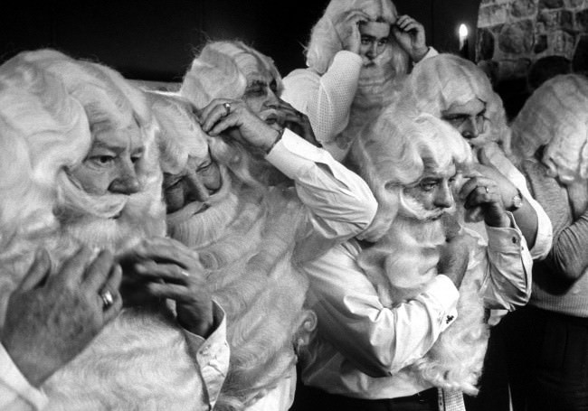 A group of men portraying Santa Claus learn how to apply their makeup, 1961.