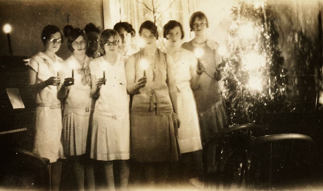 Young women hold candles before a prayer on Christmas in 1928.