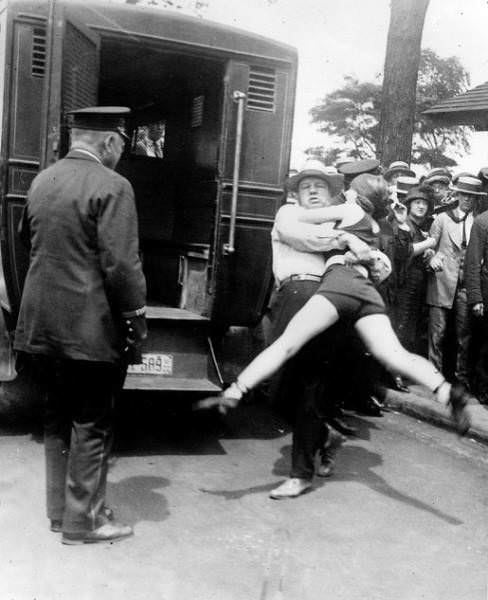 This woman is being arrested for wearing a swimsuit and having her legs uncovered. (Chicago, 1922)