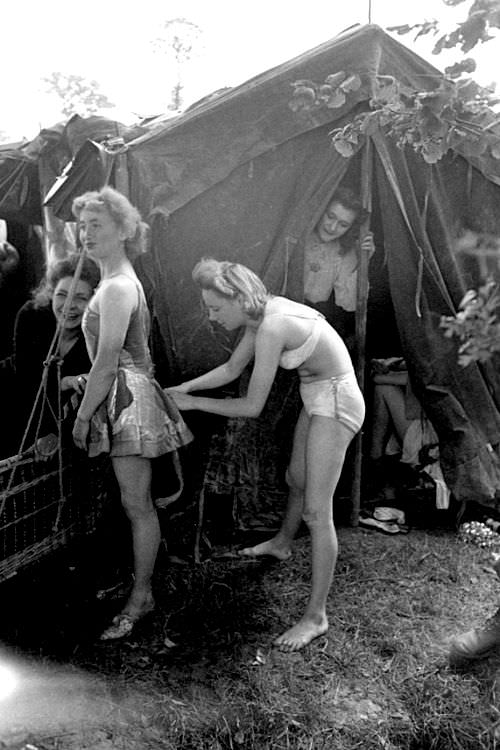 Two ladies get ready to entertain US troops in France a few weeks after D-Day in 1944. Almost immediately after getting a foothold in France, the US had showgirls entertain troops with songs and dancing. After the liberation of major cities, especially Paris, big name movie stars, comedians, and music acts came to entertain troops during USO shows. The Soviets also entertained their troops, normally with acrobatic routines or bands. The Germans also entertained their troops as well, but usually with organized events in occupied cities. Troop moral was vital by all parties in WWII, and keeping them entertained and knowing what the common soldier was fighting for was paramount. Each side did it in different ways, but it was done. The US just documented it much more during WWII due to the huge names involved.