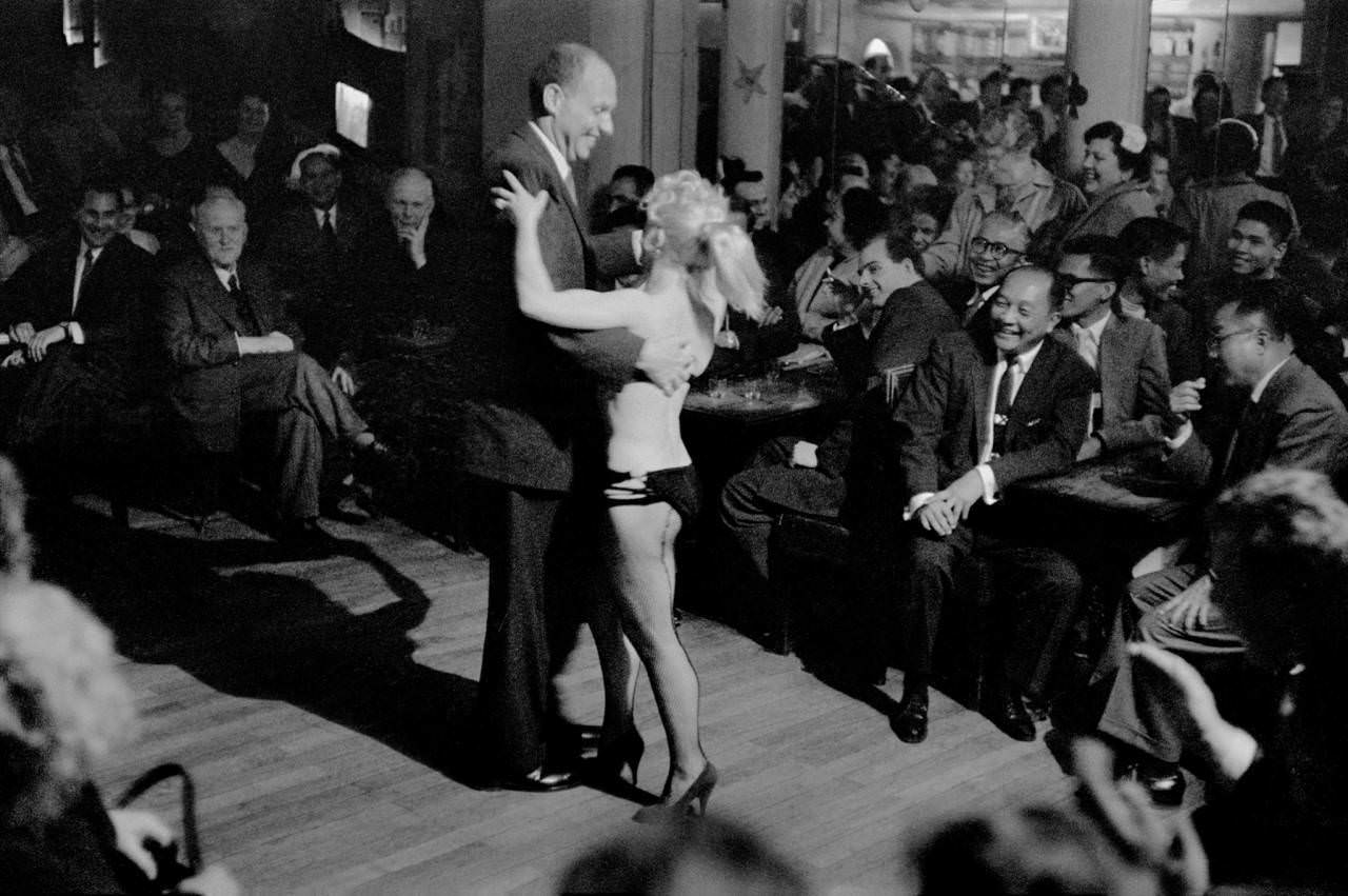 Businessmen from around the world are entertained by a dancer in Paris, France in 1958. Paris has been a key city for entertainment not seen around the world for hundreds of years, and the 1950s was no different. Many major European businesses would hire clubs in Paris to entertain investors or key executives. It was easier to do it in Paris where it was completely acceptable than try it in other countries which hadn't caught up sexually to the French. By the 1970s, that would all change as pornography, stripping and of course risque but acceptable images and films depicting adult material became available worldwide.