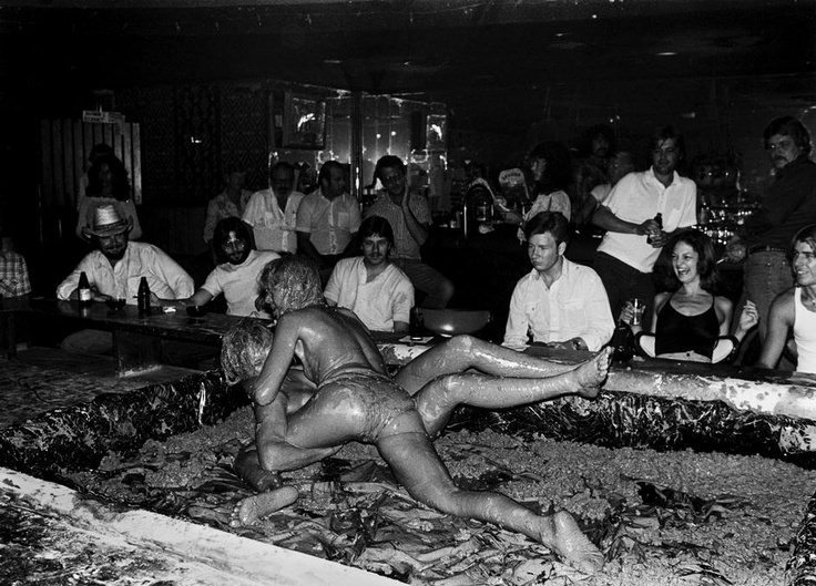 Women mud wrestle at the Sand Box Lounge in Phoenix, Arizona in 1980. During the late 1970s and 1980s, many clubs came up with weird ways to entertain clients besides just attractive women stripping. A major reason for this was the mass production of nude magazines and the expansion of pornography. Strip clubs struggled to make money and as with any business, owners tried wild new ways to keep customers and to entertain. These gimmicks were entertaining and fun at first, but most patrons didn't care for them after a while, and they mostly died out by the early 1990s. Some places still do such things, but they are few and far between.