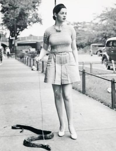 Walking a pet snake, 1930s.