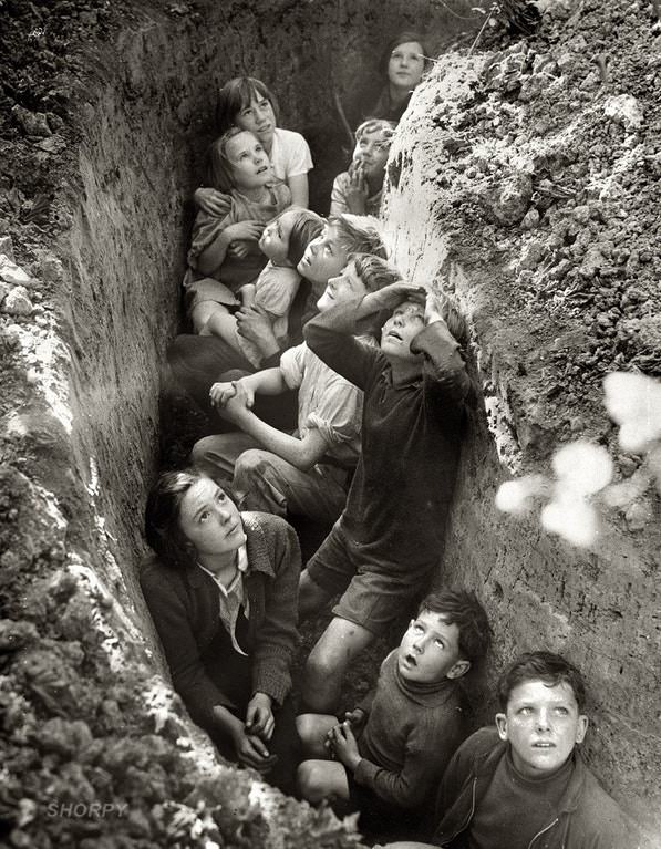 British children taking shelter in a slit trench during a German bombing raid, 1940.