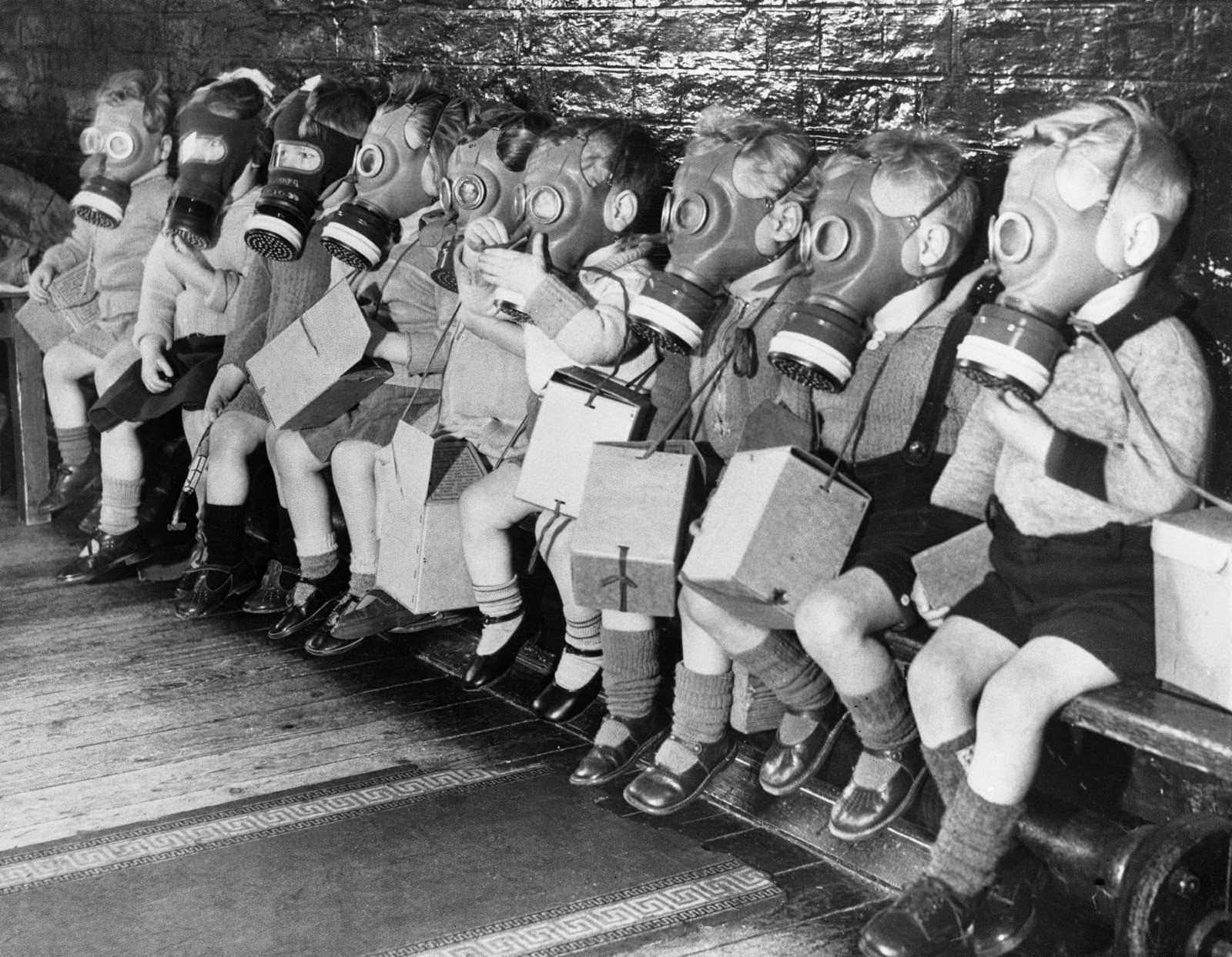 Toddlers wearing gas masks during a drill somewhere in England, 1941.