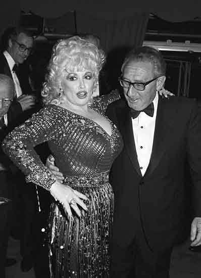 Henry Kissinger discusses politics with Dolly Parton.