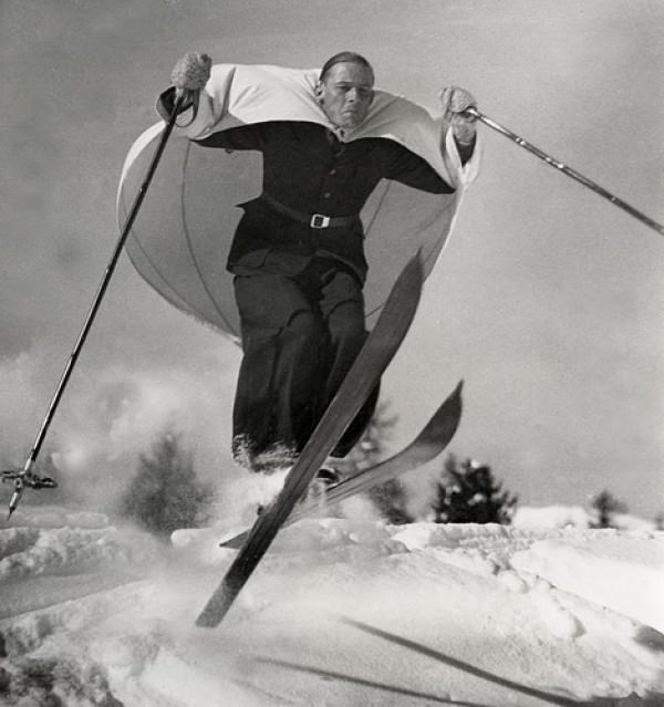 A man skiing in the Alps wearing a cap to catch air and slow down his jumps in 1948.