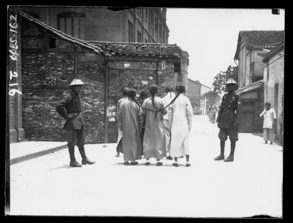 Prisoners with their long hair tied to each other preparing to be moved out somewhere in China, 1902.