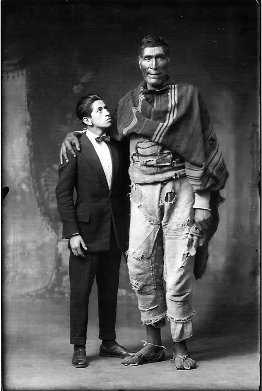 A man called "The Giant from Peru" is pictured next to an actor for scale, 1925.