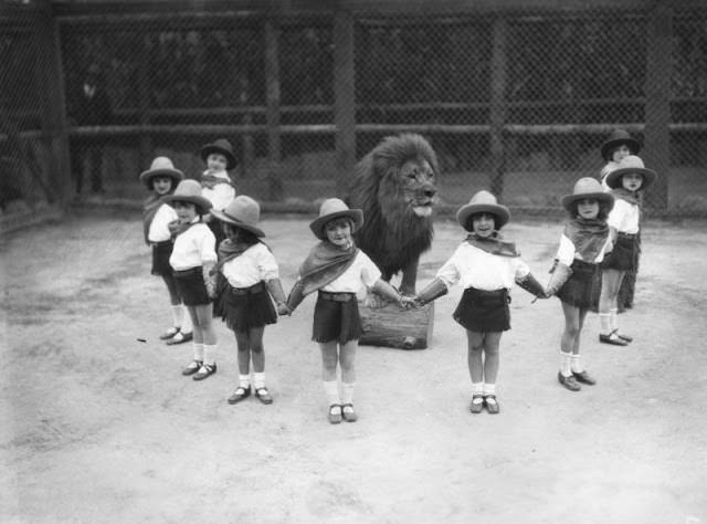 Children surround a lion during a show on Charles Gay's Lion Farm in LA, US in 1934.