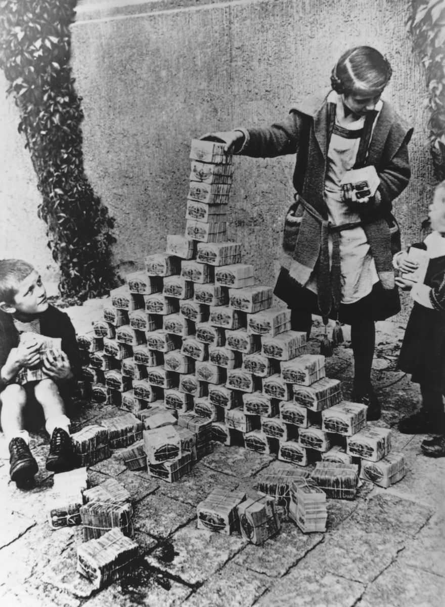 Children playing with tons of cash that became worthless after WWI in Berlin, Germany in 1920.