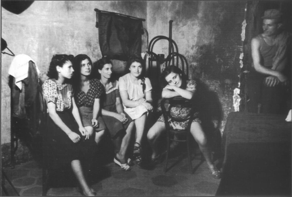 Prostitutes and a manager wait for customers in a brothel in Naples, Italy in 1945. The majority of their customers at the time were US soldiers.
