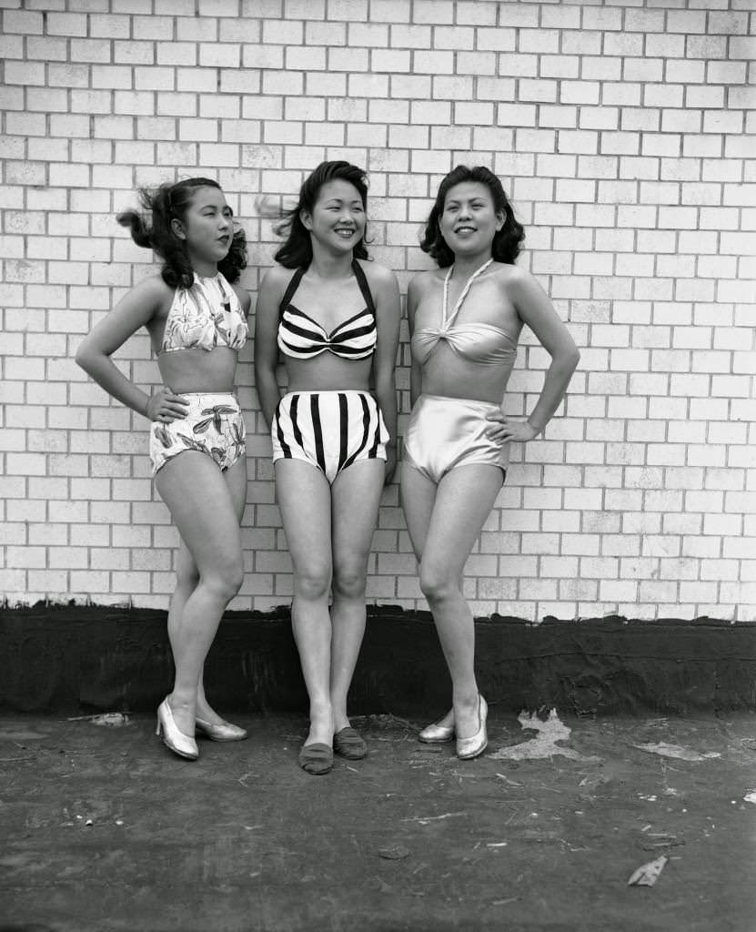 Mitsuso Kitajima, Akiko Yoyogi and Yoshiko Kubomura show off new bathing suits at the Imperial Theater in Tokyo, Japan in 1946.