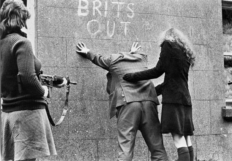 This IRA propaganda picture shows female IRA members checking a loyalist civilian for arms in Northern Ireland in 1972. This was part of a number of pictures released by the IRA showing faceless women in action. The weapons and female IRA members are real, but the scenario is staged. This kind of picture was designed to give the impression the IRA was everywhere, and could be anyone at anytime. This was during the earlier stages of The Troubles, which lasted 30 years from 1968 through 1998. Throughout this time, female IRA members often played traditional roles such as secretaries or organizers, sometimes also as spies or support roles, but plenty were also active soldiers. As the Troubles ramped up, more women joined both sides. The IRA tends to be better known, but there was also a lot of Northern Irish people who joined loyalist factions or government agencies in efforts to suppress the IRA.