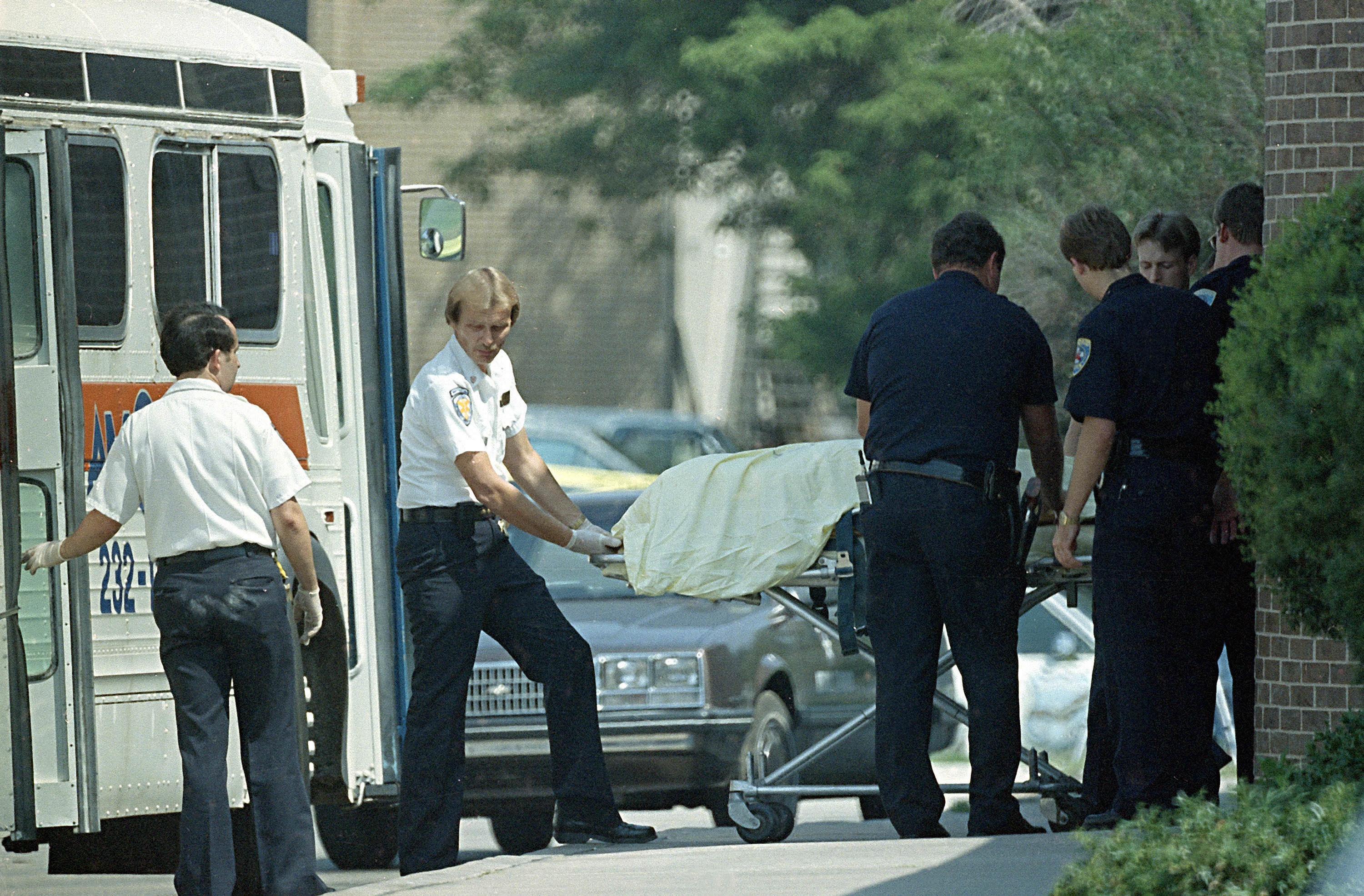 Police and emergency personnel wheel out a body after the Edmond Post Office Shooting in Edmond, Oklahoma, US in 1986. A postal worker named Patrick Sherrill entered the building and in 15 minutes hunted and shot 20 former coworkers. He killed 14 of them before he committed suicide as police began to surround the building. Motives for his actions are debated, but many presume he was to be fired after a mistake the previous day and committed the shootings when the anxiety took him over. At the time it was 3rd worst mass shooting in the US. The event shocked the nation, and any term today referring to "going postal" is a direct reference to this shooting.