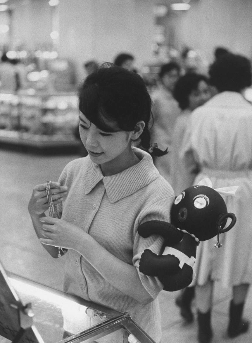 A woman wears the Dakko-chan toy on her arm as part of the odd Dakko-chan craze in Japan, 1960.