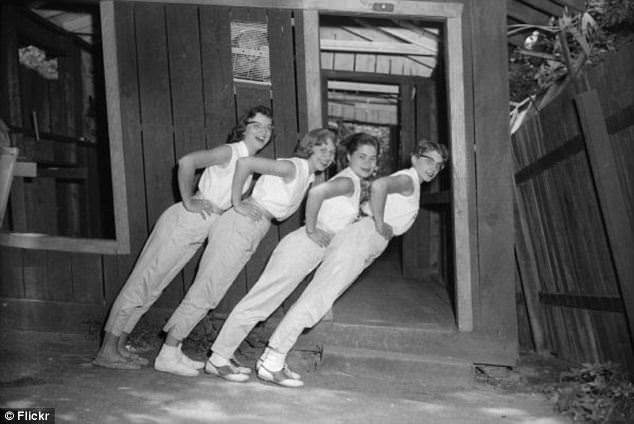 People pose for a picture at the tourist destination of "Wonder Spot" in Wisconsin, US in 1957. The place is built on a plane to give off the illusion of a tilt in pictures such as this.